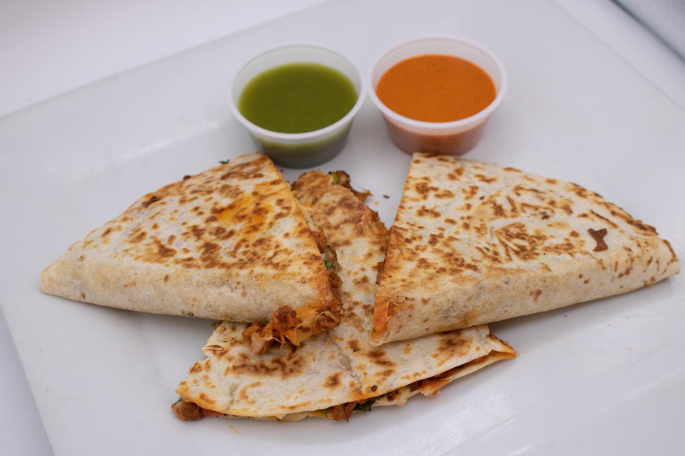 A quesadilla with two salsas